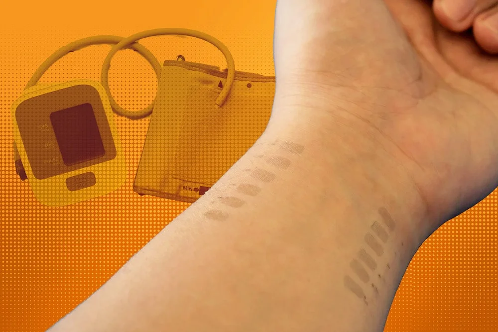 Graphene bioimpedance e-tattoo - University photograph of the graphene blood-pressure e-tattoo on a wrist with study electronics.